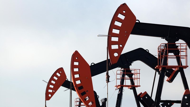 A group of oil pumps against a cloudy sky.