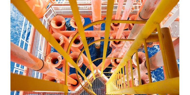 Aerial view of the drill of an oil rig, submerged into the ocean below.