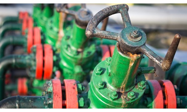 A group of green and red valves on a pipeline.