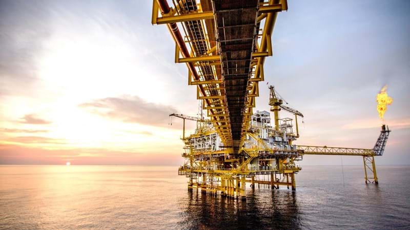A close-up from underneath the connecting platform of an oil rig in the ocean.