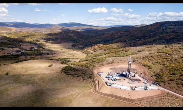 An aerial view of a drilling rig in the mountains.