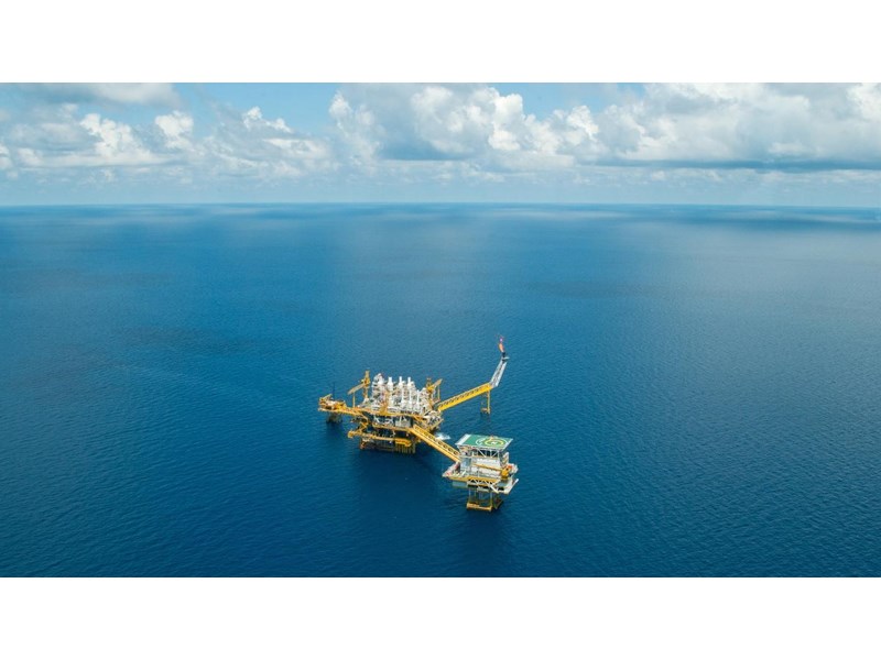 An aerial view of an oil rig in the open ocean.