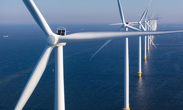 A close-up of a row of wind turbines in the open sea,