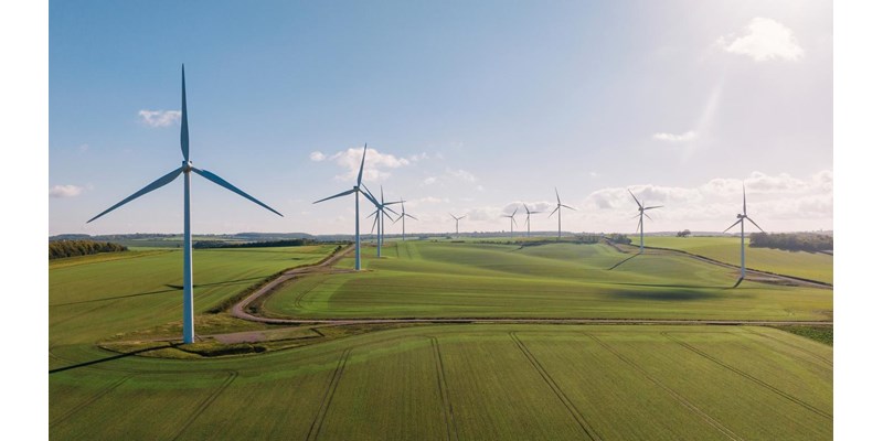 Aerial view of wind turbines in a field, on a sunny day.