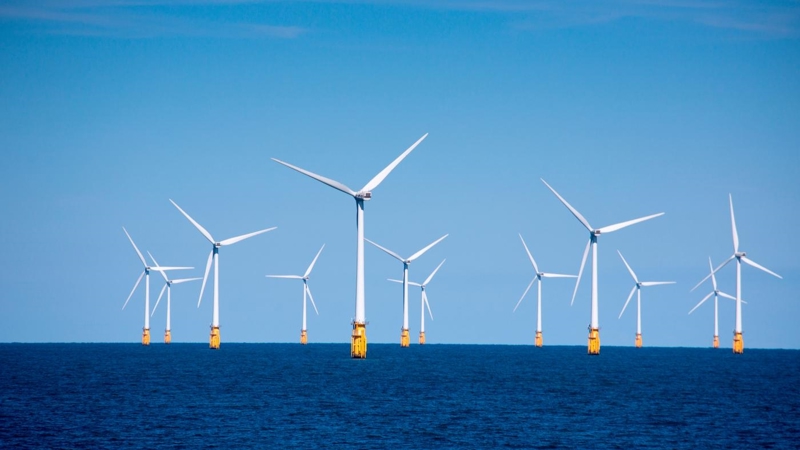 A group of wind turbines in the ocean.