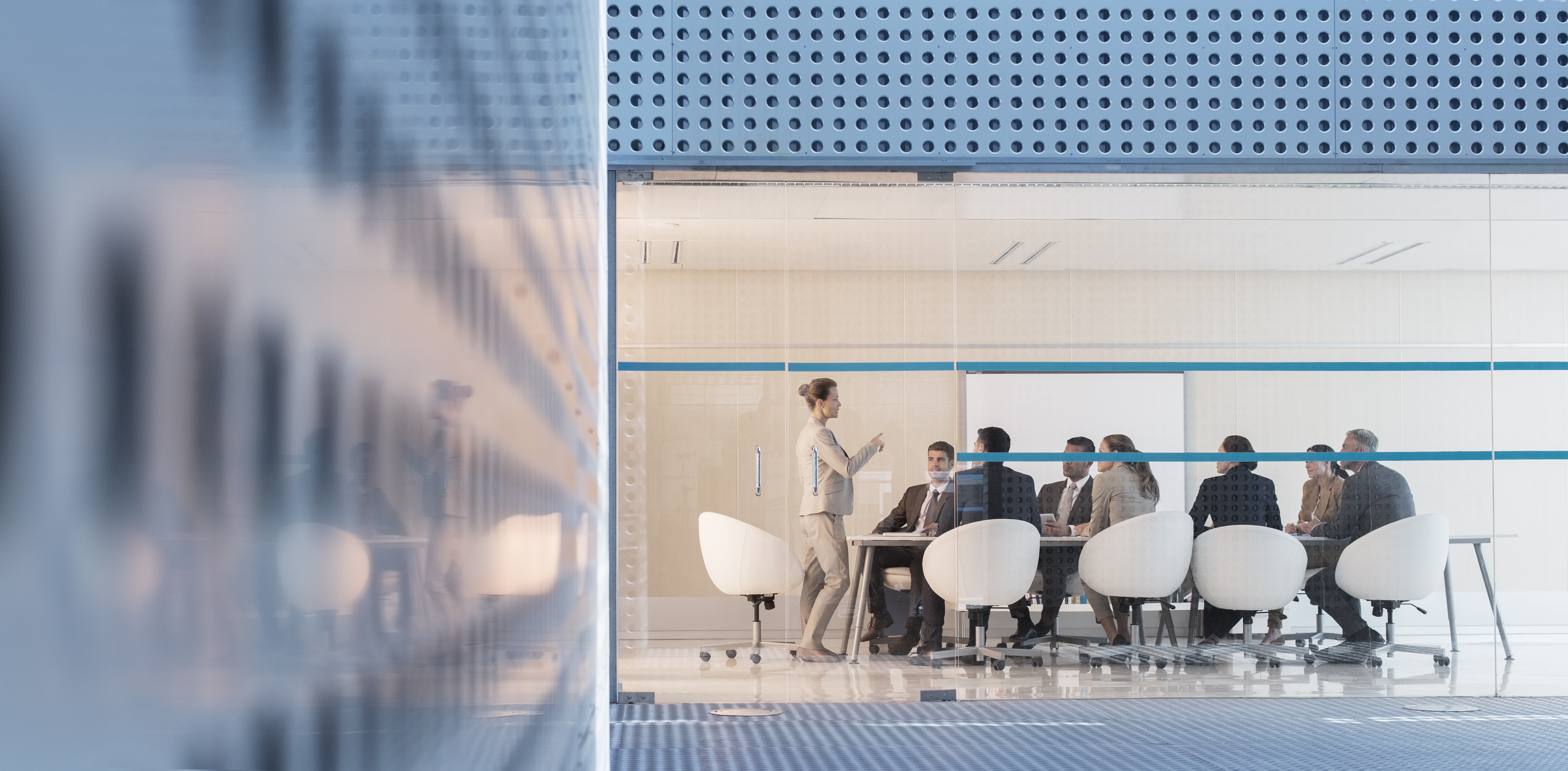 Greater inclusion and diversity has been shown to boost corporate performance. Image shows woman speaking in boardroom meeting 