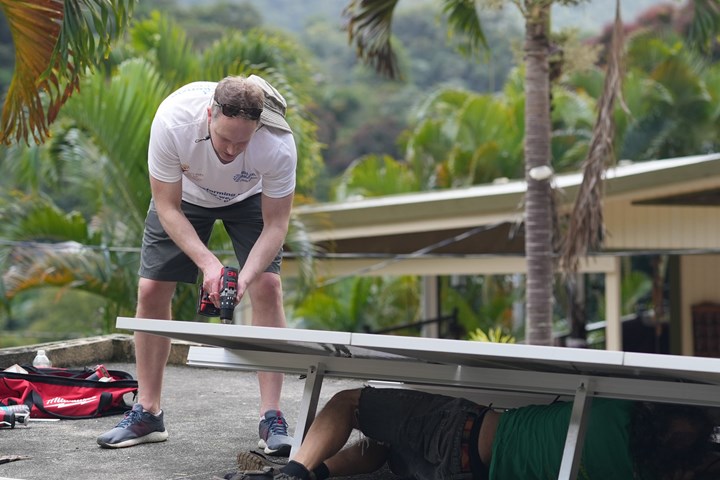 Image shows Luke Lewandowski installing a solar panel